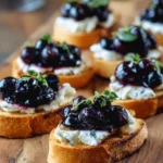 Blueberry goat cheese crostini appetizer with fresh blueberries and herbs