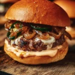 Jalapeño-onion smash burger with toppings on a grill plate
